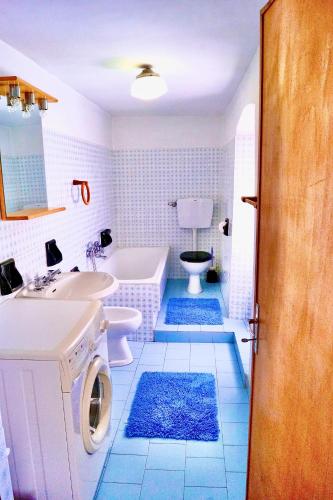 a bathroom with a tub and a sink and a toilet at Casa rustica di montagna in Gignod