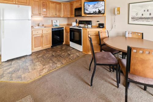 a kitchen with a table and a white refrigerator at ML229 Mountain Escape Great for Relaxing Near Village in Snowshoe