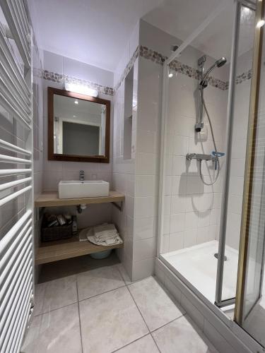 une salle de bain avec une douche, un lavabo et un miroir dans l'établissement L'Aigue Marine, à Saint-Jean-de-Monts