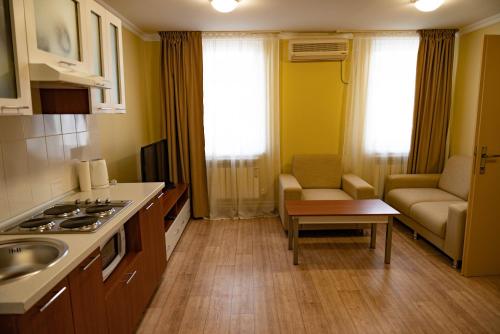 a kitchen with a sink and a couch in a room at Chagala Hotel Aksai in Aksay