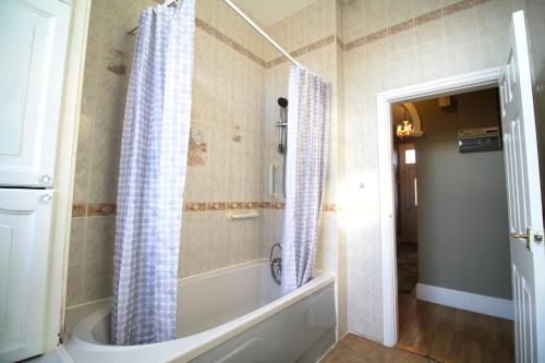 a bathroom with a bath tub and a shower at Large Bungalow - Sleeps 8 - 3 Large Beds - Plus Sofa Bed - Off Street Parking - Very Large Enclosed Gardens - Fast Wifi in Birmingham