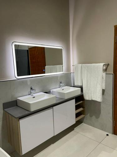 a bathroom with two sinks and a mirror and towels at DUBE SAFARI LODGE at Kruger Park Lodge 505 in Hazyview