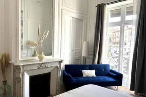 un salon avec un canapé bleu et une cheminée dans l'établissement Casa Kûta - Place de la Comédie, Montpellier, à Montpellier