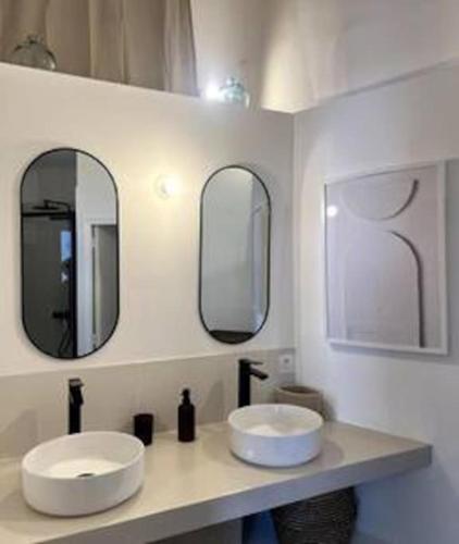 deux lavabos dans une salle de bain avec deux miroirs dans l'établissement Casa Kûta - Place de la Comédie, Montpellier, à Montpellier