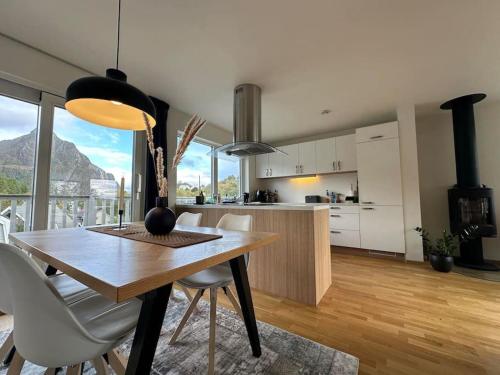 a kitchen and dining room with a table and chairs at Exclusive apartment with great views close to city center in Svolvær