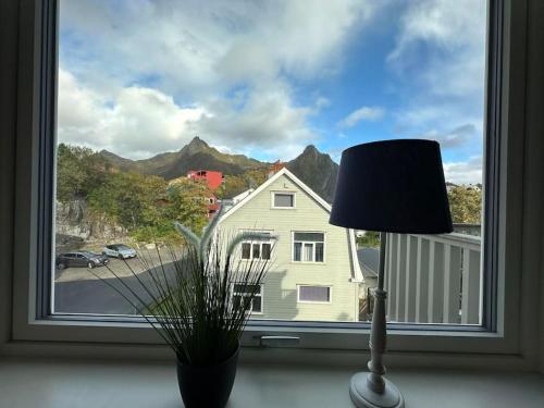 a window with a plant and a lamp in front of it at Exclusive apartment with great views close to city center in Svolvær