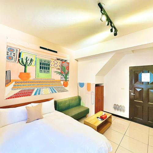 a bedroom with a white bed and a green couch at 莫蘭狄 in Taichung