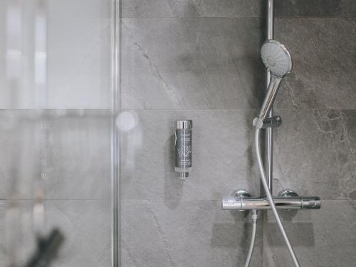 a shower with a glass shower door with a shower at Haus Altenberger by we rent, SUMMERCARD INCLUDED in Zell am See