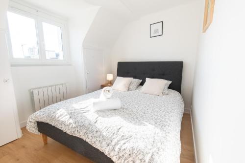 - une chambre blanche avec un grand lit et des draps blancs dans l'établissement PREMIUM T2 neuf 4ème étage ultra Centre Lorient par Groom, à Lorient