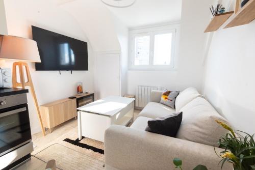 un salon avec un canapé et une télévision dans l'établissement PREMIUM T2 neuf 4ème étage ultra Centre Lorient par Groom, à Lorient