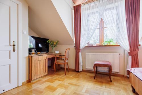 a bedroom with a desk with a computer and a window at Dwór Prezydencki Boutique Hotel & SPA in Tarnów