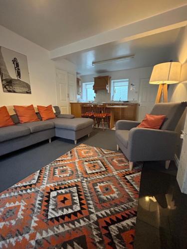 a living room with two couches and a rug at Central Town House, Moville in Moville