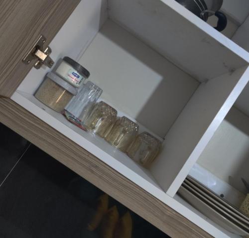 een witte plank met glazen potten erop bij Jessy stays in Nairobi