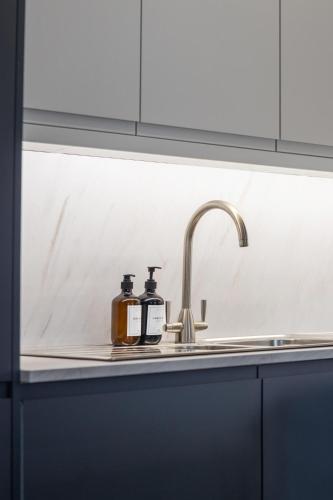 two bottles of soap sitting on a kitchen sink at Modern Brixton Apartments in London