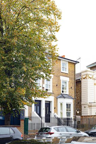 a house with cars parked in front of it at Modern Brixton Apartments in London