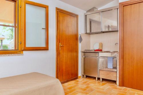 a room with a kitchen with a bed and a door at ISA-Village with swimming-pool and private equipped beach in Montalto Marina in Torre di Montalto