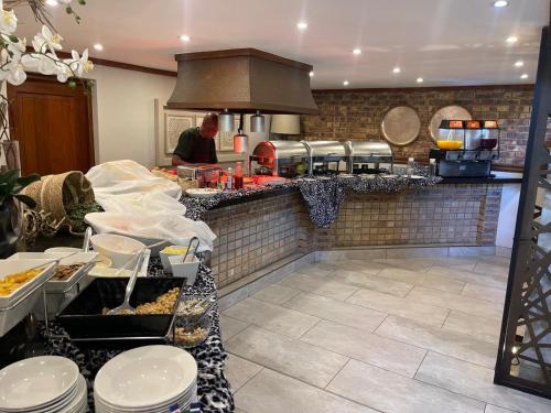 a man in a kitchen preparing food in a kitchen at DUBE SAFARI LODGE at Kruger Park Lodge 505 in Hazyview