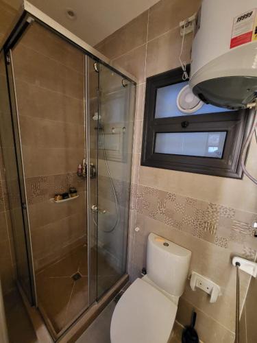 a bathroom with a toilet and a glass shower at Madinity B8 - Fantasy Studio in Madinaty