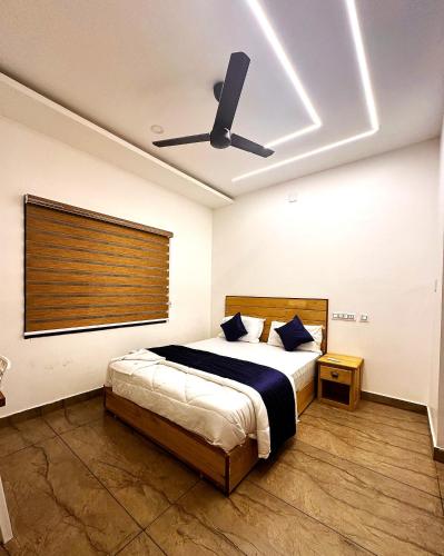 a bedroom with a bed and a ceiling fan at Grandstaykannur in Kannur