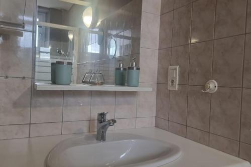 une salle de bain avec un lavabo et un miroir dans l'établissement Le Petit Broche, spacious, sleeps 6, à Xonrupt-Longemer