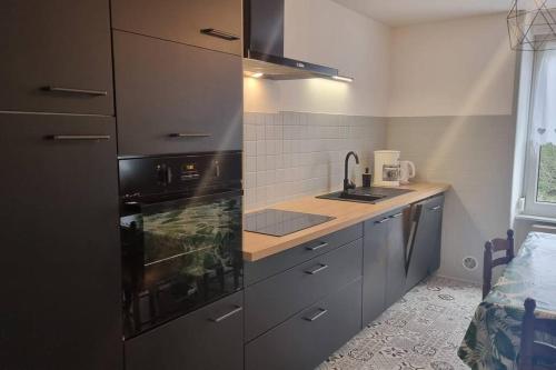 une cuisine avec un évier et une cuisinière dans l'établissement Le Petit Broche, spacious, sleeps 6, à Xonrupt-Longemer