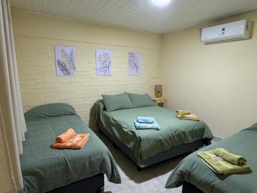 ein Schlafzimmer mit zwei Einzelbetten und Zeichnungen an der Wand in der Unterkunft Las Castañas in General Acha