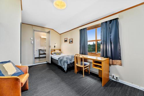 a hotel room with a bed and a desk and a chair at Lakselv Hotel in Lakselv