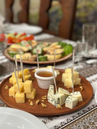 a plate of cheese on a table with dipping sauce at Georgiy in Oryavchyk