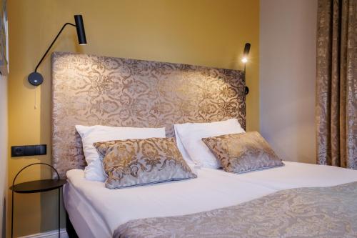 a bed with two pillows on top of it at Dwór Prezydencki Boutique Hotel & SPA in Tarnów