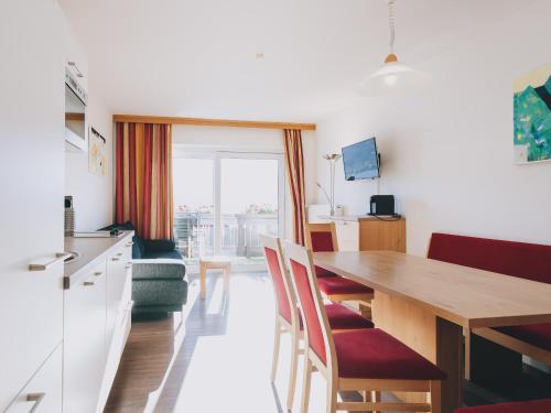 a kitchen and dining room with a wooden table and chairs at Haus Altenberger by we rent, SUMMERCARD INCLUDED in Zell am See