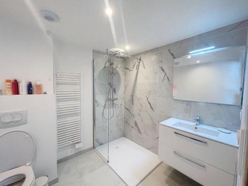 a bathroom with a shower and a sink and a toilet at Appartement avec vue panoramique sur la mer in Calvi