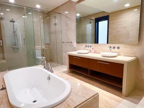 a bathroom with a tub and a shower and a sink at Luxury Seaview Family Suite at Straits Quay in Tanjong Tokong
