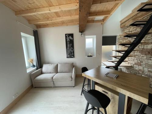 un salon avec un canapé et une table dans l'établissement Charmante maison de village, à Viré