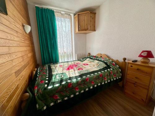 une chambre avec un lit avec une couette dessus dans l'établissement Appartement rénové 2 pièces, centre station, piscine, animaux admis - FR-1-181-2141, à La Plagne Tarentaise