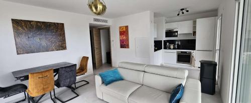 a living room with a couch and a kitchen at Appartement avec vue panoramique sur la mer in Calvi
