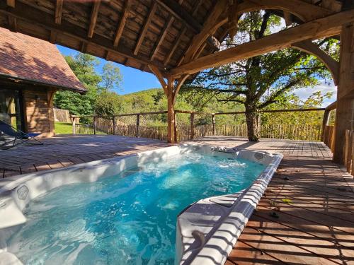 - une piscine sous une pergola en bois dans l'établissement Gîte du Château du Clos Voucheot, grand spa de nage, à La Bussière-sur-Ouche