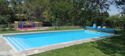 - une piscine dans une cour avec une aire de jeux dans l'établissement Le clos de la garrigue, à Nîmes