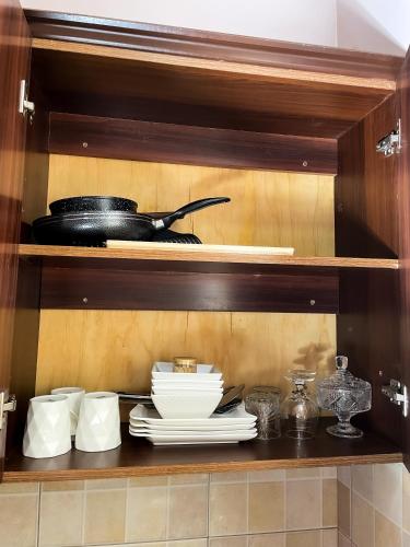 a shelf with plates and utensils in a kitchen at Jay homes Najjera in Buwate