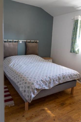 a bedroom with a bed with a white comforter at La bergerie de Genouse in Marnay