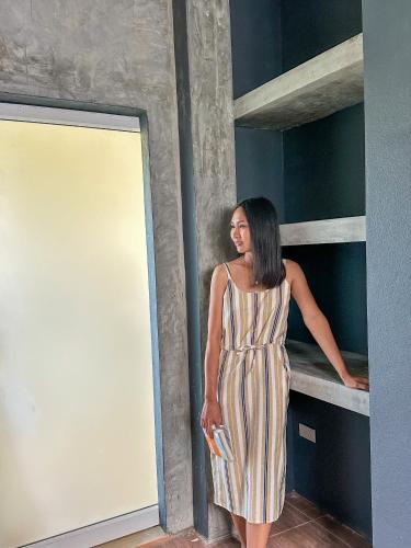 a woman in a striped dress standing on a bunk bed at JJ and J Garden1 Pai in Pai