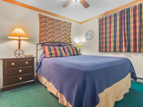 a bedroom with a bed with a blue comforter at ML286 Beautiful Views New Deck WiFi EZ Parking in Snowshoe