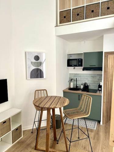 une cuisine avec une table en bois et deux chaises dans l'établissement Casa Urbä - Place de la Comédie, Montpellier, à Montpellier