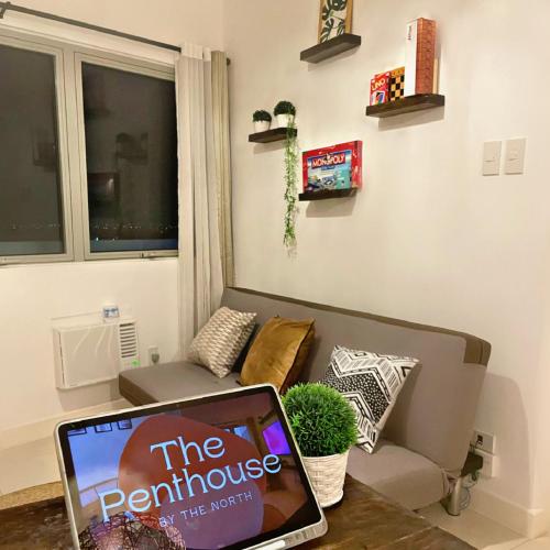 a laptop sitting on a table in a living room at 1 Bedroom Penthouse 3BEDS Sunset & City lights with big balcony FREE ACCESS to all amenities in Manila