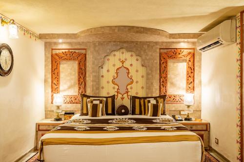 a bedroom with a large bed and two windows at Chokhi Dhani The Ethnic 5-Star Deluxe Resort in Jaipur