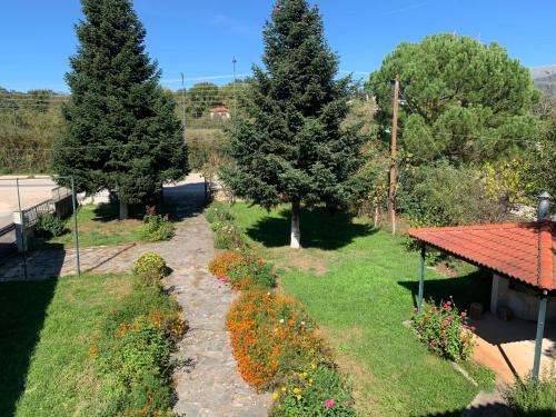 a garden with flowers and trees and a pathway at Aelias home in Eleoúsa