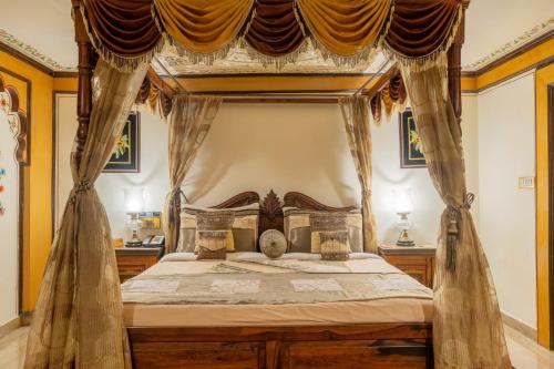 a bedroom with a canopy bed with curtains at Chokhi Dhani The Ethnic 5-Star Deluxe Resort in Jaipur