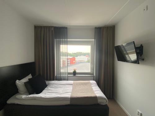 a bedroom with a bed with a window and a television at Forenom Hotels & Apartments Flemingsberg - 10min from Älvsjö in Huddinge