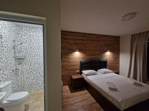 a bedroom with a bed and a bathroom with a toilet at White villas in Batumi in Batumi