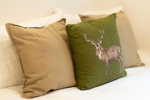 un'applique di cervo su un cuscino verde su un divano di The Stables Cottage, Aboyne, Peaceful Stay in Royal Deeside ad Aboyne