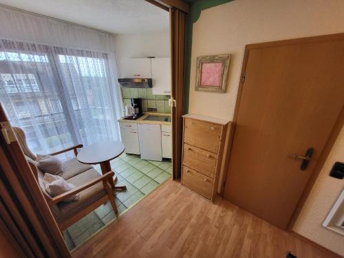an open door to a kitchen with a chair and a table at Hotel Schönblick in Bad Herrenalb